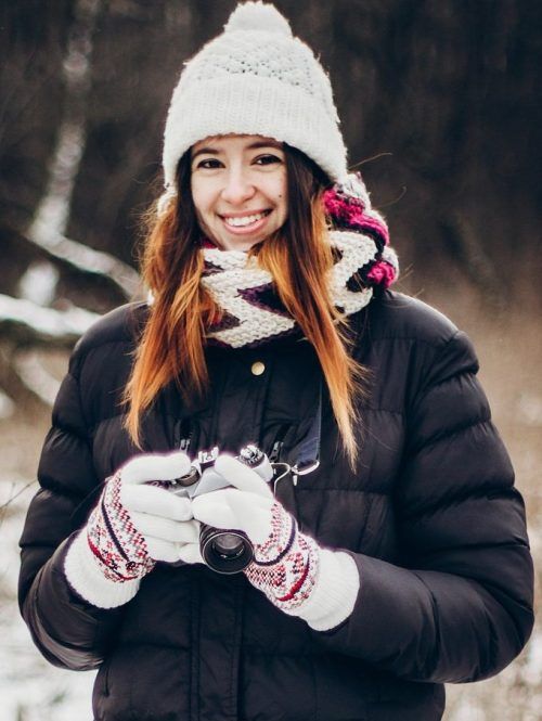 stylish hipster traveler girl with old photo camera exploring in snowy woods in winter e1631427949166